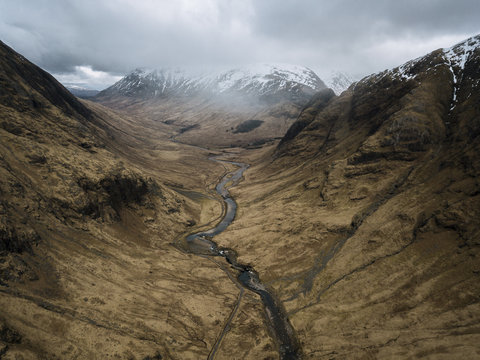 Aerial perspective of a mountain valley with road and river in Glen Coe, Scotland on a moody day