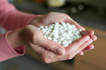 Woman's cupped hands full of pills