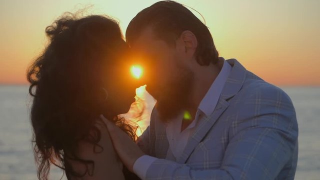 Portrait of young attractive couple dancing latin bachata near sea or ocean. Sunlight background. Summer time, romantic footage. Slow motion.