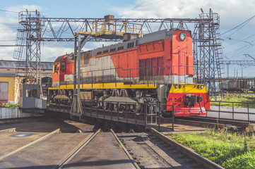 Fototapeta na wymiar Sunny day, freight electric locomotive on a turntable with rails