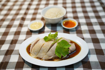 Steamed chicken with soy sauce, served with white rice also known as Hainanese Chicken Rice, Singapore food recipe, Popular in Thailand. 