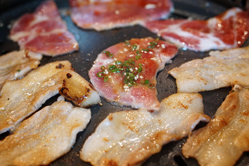 Grilling raw sliced pork on the hot charcoal stove, Japanese barbecue style , also know as Yakiniku.