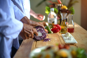 hand of chef cutting red cabbage slice in a part of bits for salad vegetable in kitchen, serving new and fresh always