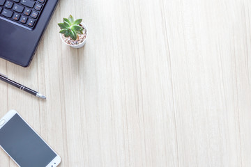 Wood office desk table with laptop,smartphone,cactus pot and pen with copy space