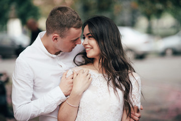 Happy young couple in love enjoys spring day, loving man holding on hands his woman carefree walking at park