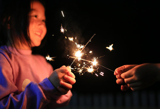 Little Asian child girl enjoy playing firecrackers.