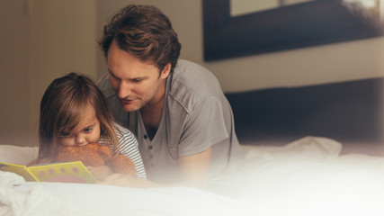 Father and daughter reading a story book