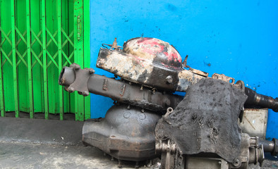 rusty spare parts on a blue wall and green door