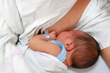 Obraz na płótnie Canvas Mother breast feeding her newborn child. 