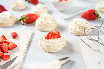 A small meringue Pavlova dessert with some strawberry slices . Top view. pattern