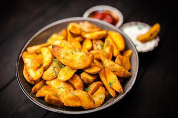 Baked potato fries on wooden table