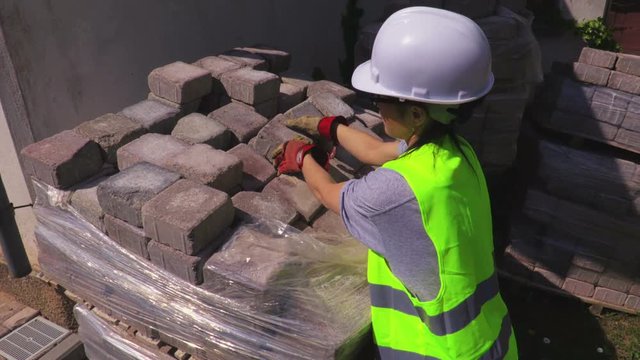 Woman builder sorting bricks at outdoor