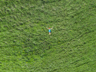 Obraz na płótnie Canvas Aerial view of a woman lying in a grass