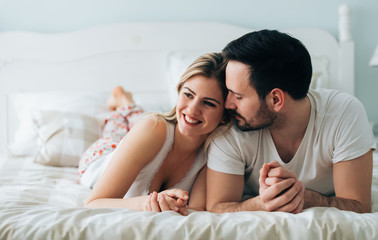 Portrait of young loving couple in bedroom