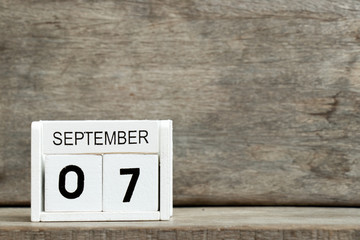 White block calendar present date 7 and month September on wood background