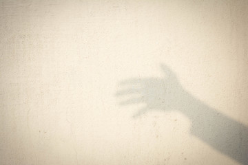 shadow of human hand on abstract wall
