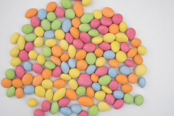 Small colorful chocolate candies on a white background