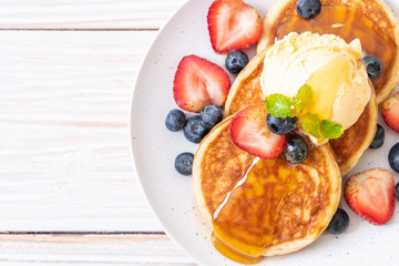 pancake with blueberries, strawberries, honey and vanilla ice-cream