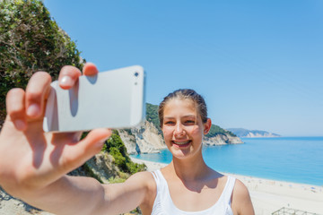 Girl taking a selfie on the beach, summer vacations.