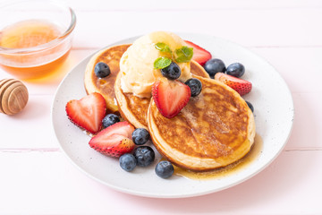 pancake with blueberries, strawberries, honey and vanilla ice-cream