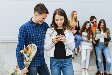 Summer holidays and teenage concept - group of smiling teenagers with skateboard hanging out...