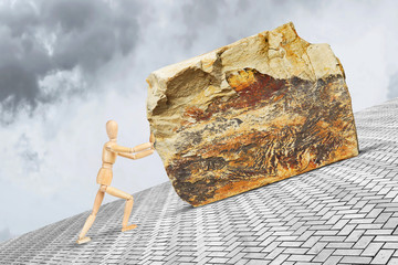 Man pushes the heavy and large stone upward along the slope with effort. Conceptual image with a wooden puppet