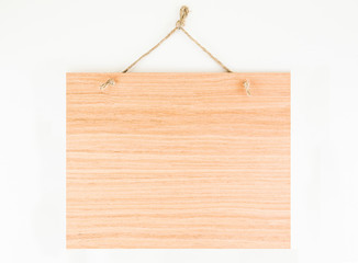 Labels made of natural wood, with a rope hanging on a white background, are empty.