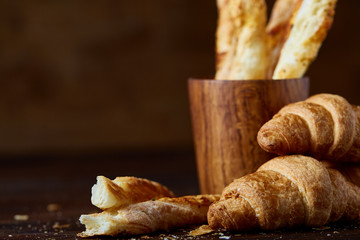 Tasty buttery croissants on an old wooden table, close-up, selective focus, shallow depth of field.
