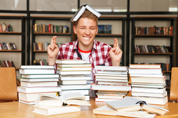 Smiling teenage boy sitting at the library table