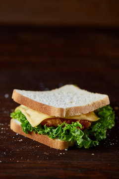 Tasty and fresh sandwiches on cutting board over a dark wooden background, close-up