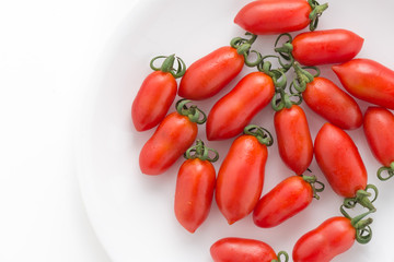 red tomatoes in plate on isolated white background

