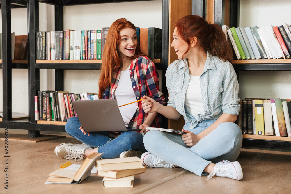 Canvas Prints Two excited teenage girls sitting on a floor