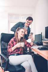 Colleagues using mobile phone together