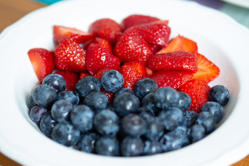 Strawberries and blueberries in a white bowl
