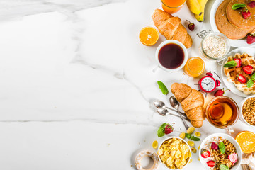 Healthy breakfast eating concept, various morning food - pancakes, waffles, croissant oatmeal sandwich and granola with yogurt, fruit, berries, coffee, tea, orange juice, white background