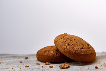 Pile of oat cookies on homespun napkin, close-up, selective focus.