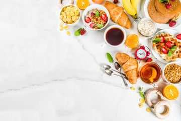 Healthy breakfast eating concept, various morning food - pancakes, waffles, croissant oatmeal sandwich and granola with yogurt, fruit, berries, coffee, tea, orange juice, white background - Powered by Adobe