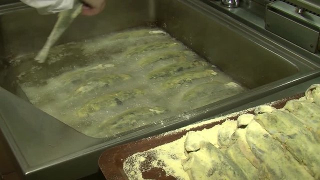 Fish fried in a frying pan until golden brown,Pieces of fresh fish are fried in a frying pan in flour and they are turned with a fork.Chef is cooking fish.Preparing of fish for frying.