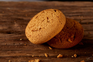 Pile of oat cookies on wooden table, close-up, selective focus.