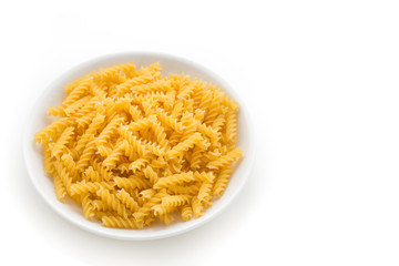 raw pasta in white plate on isolated white background

