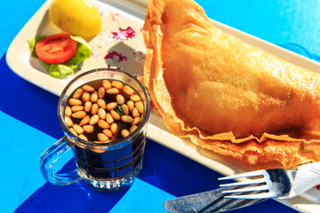 Pastries with meat  and tea with pine nuts and mint.