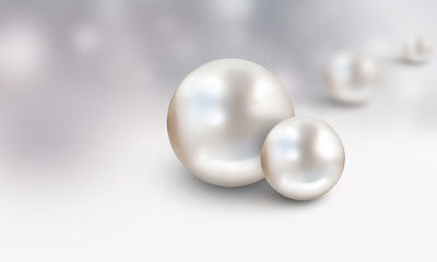 Two large white with blurred pearls in background on grey and white cloudy  background