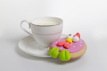 Cup with milk and cake on a saucer on a white background