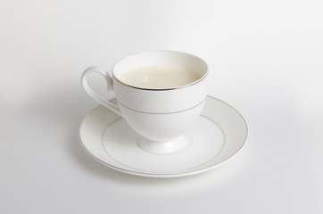 White cup with milk on white background