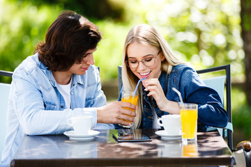 Young romantic couple spending time together - sitting in cafe's garden