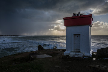 phare sur la côte bretonne, averse à l'horizon
