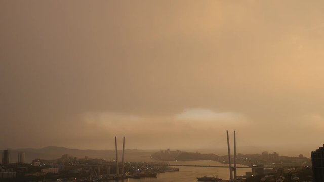 Lightning storm over city at sunset.