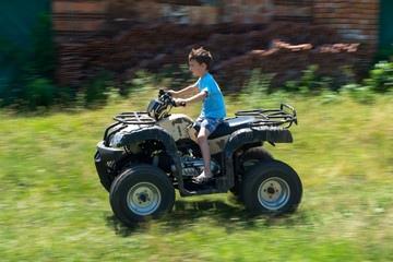 Fototapeta na wymiar The boy is traveling on an ATV.