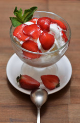Vanilla ice cream with chopped strawberries and a mint leaf