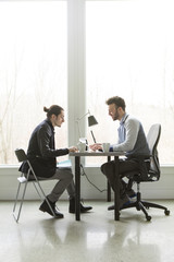Young Businessmen at an Office Desk